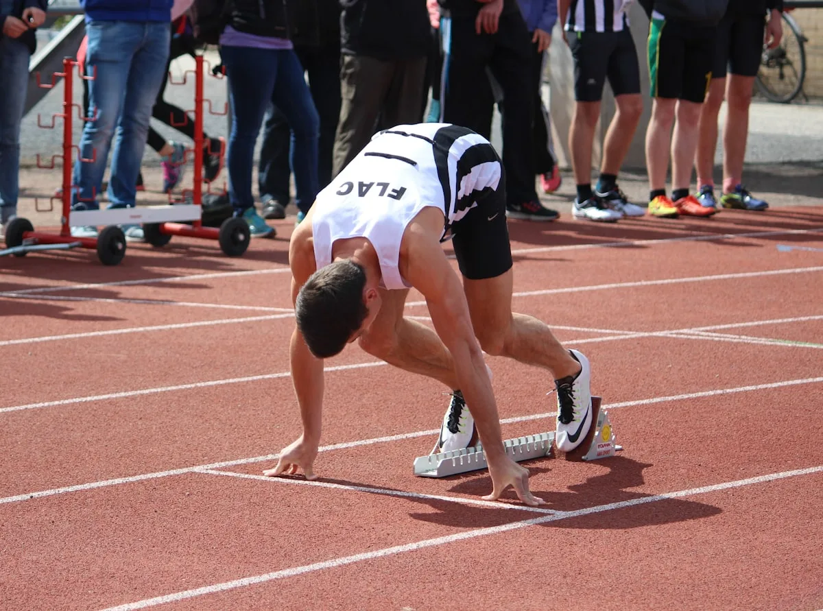 Un athlète accroupi dans les starting-blocks
