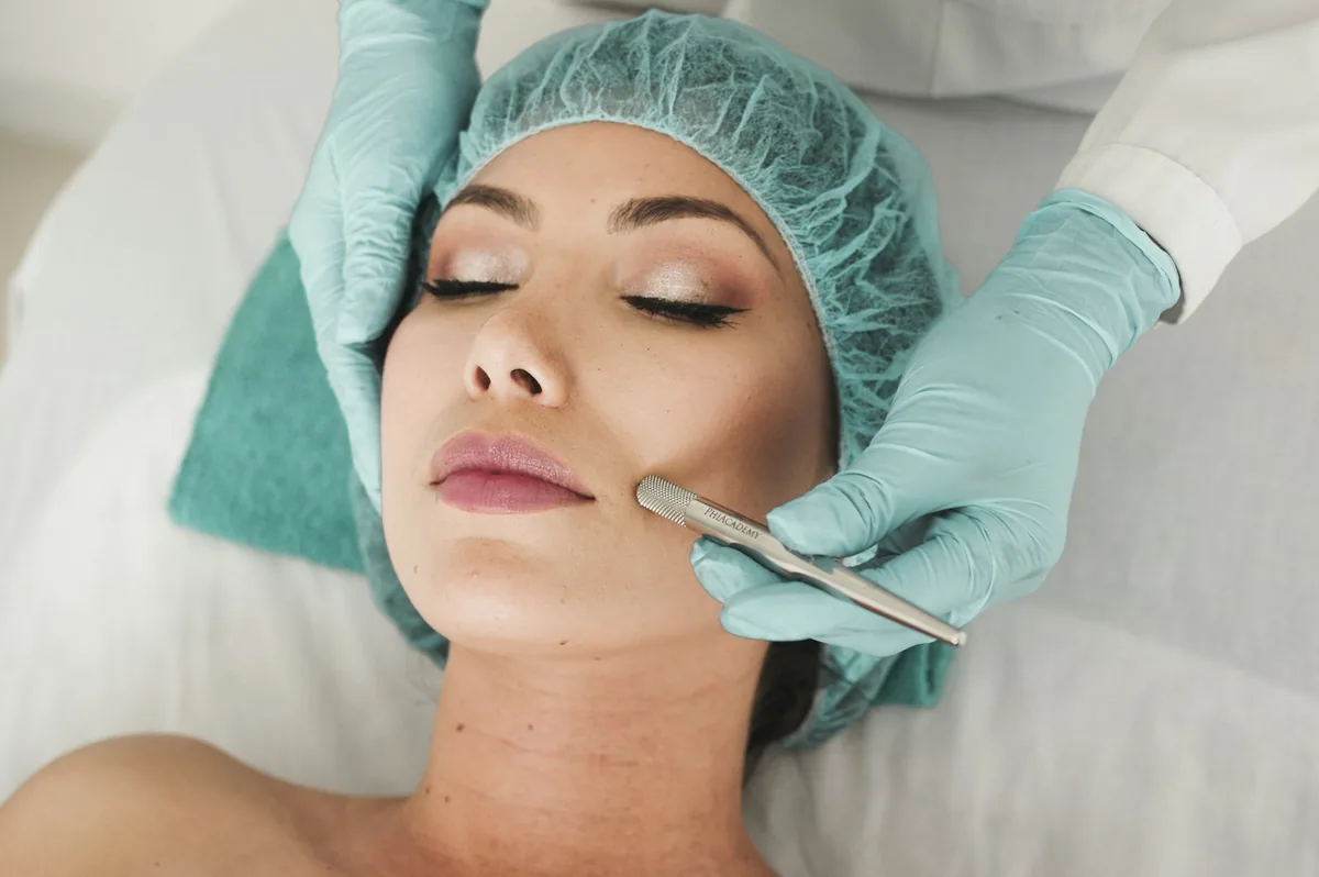 Une praticienne gantée pratique un soin du visage