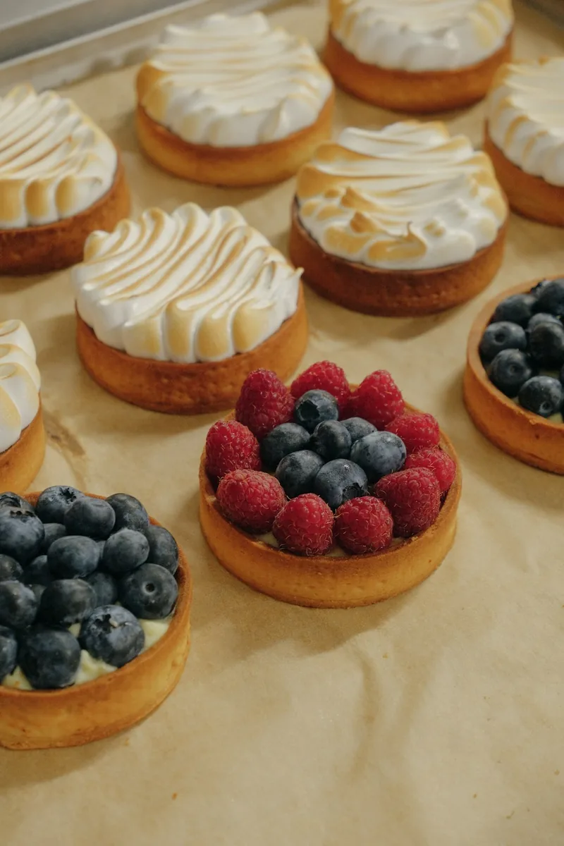 Des tartelettes meringuées et aux fruits rouges sur papier cuisson
