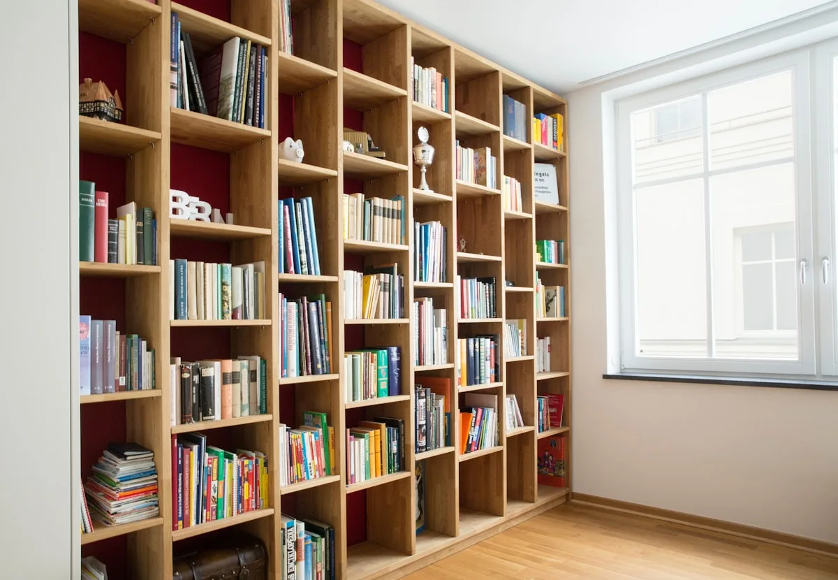 Bibliothèque en bois toute hauteur près d'une fenêtre