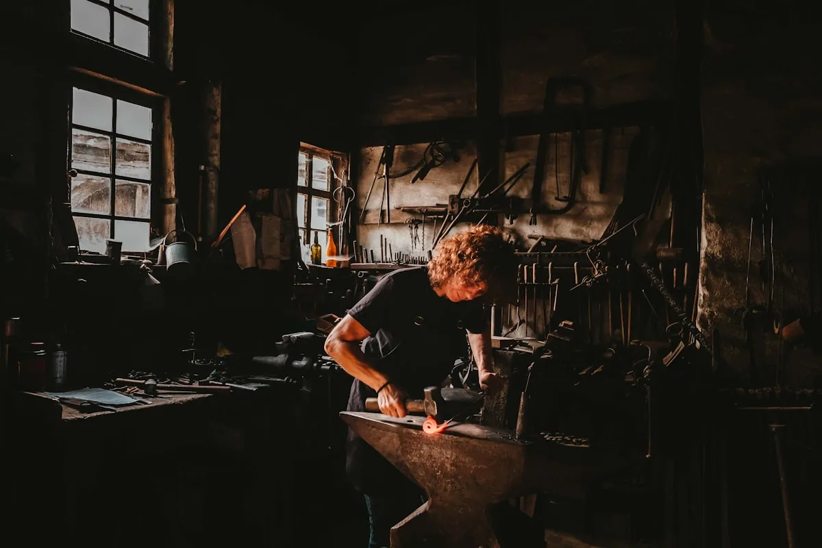 Un forgeron frappe l'enclume dans son atelier