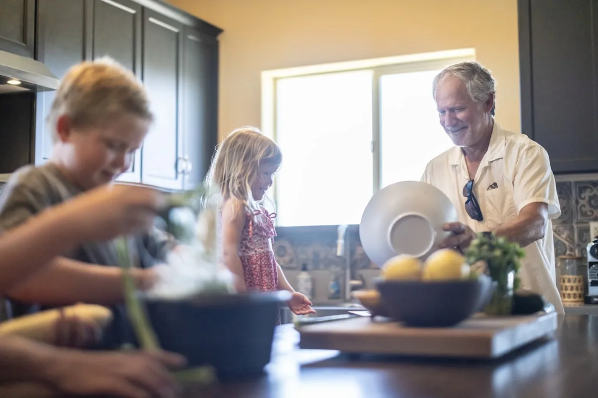 Un grand-père et deux enfants cuisinent ensemble