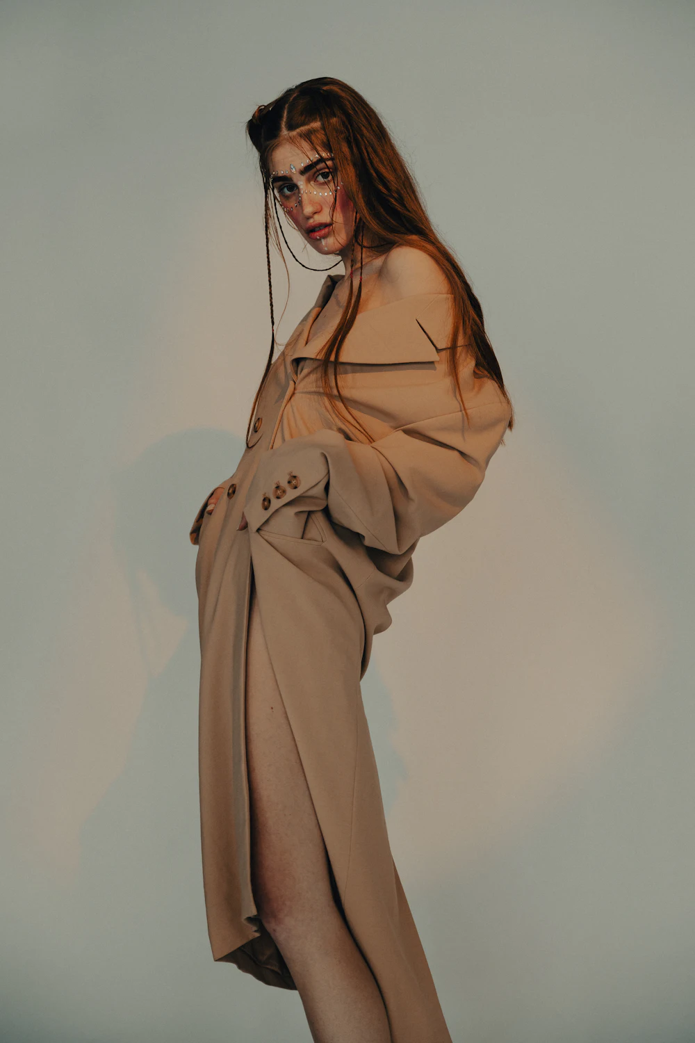 Une femme en manteau long camel, de trois quarts