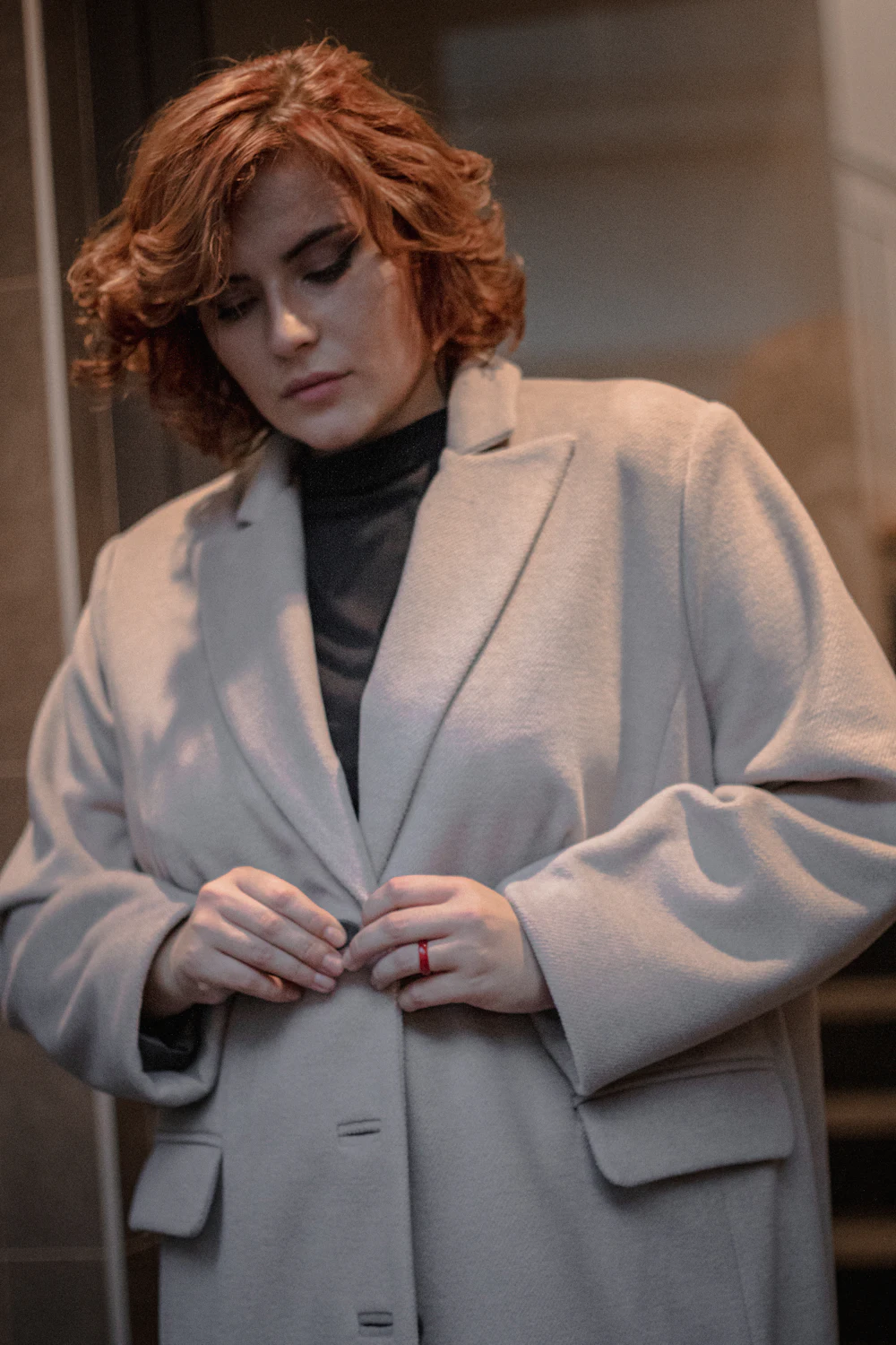 Gros plan sur le boutonnage et le revers d'un manteau gris