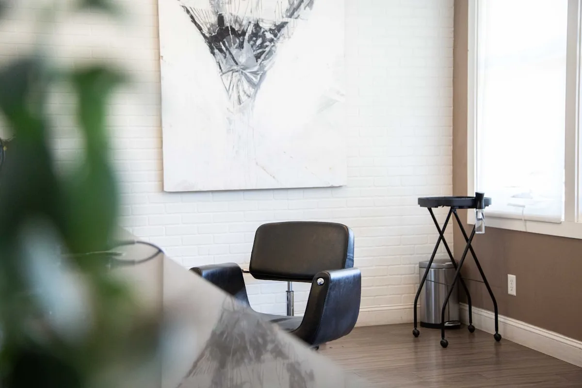 Un fauteuil de coiffure vide contre un mur clair