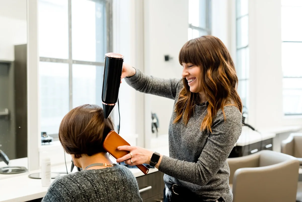 Léa sèche les cheveux d'une cliente